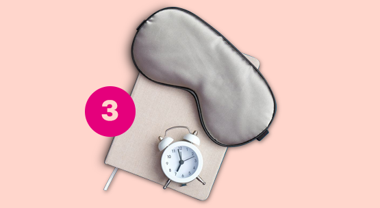 Schlafgewohnheiten Schlafmaske und Wecker liegen auf einem Tagebuch